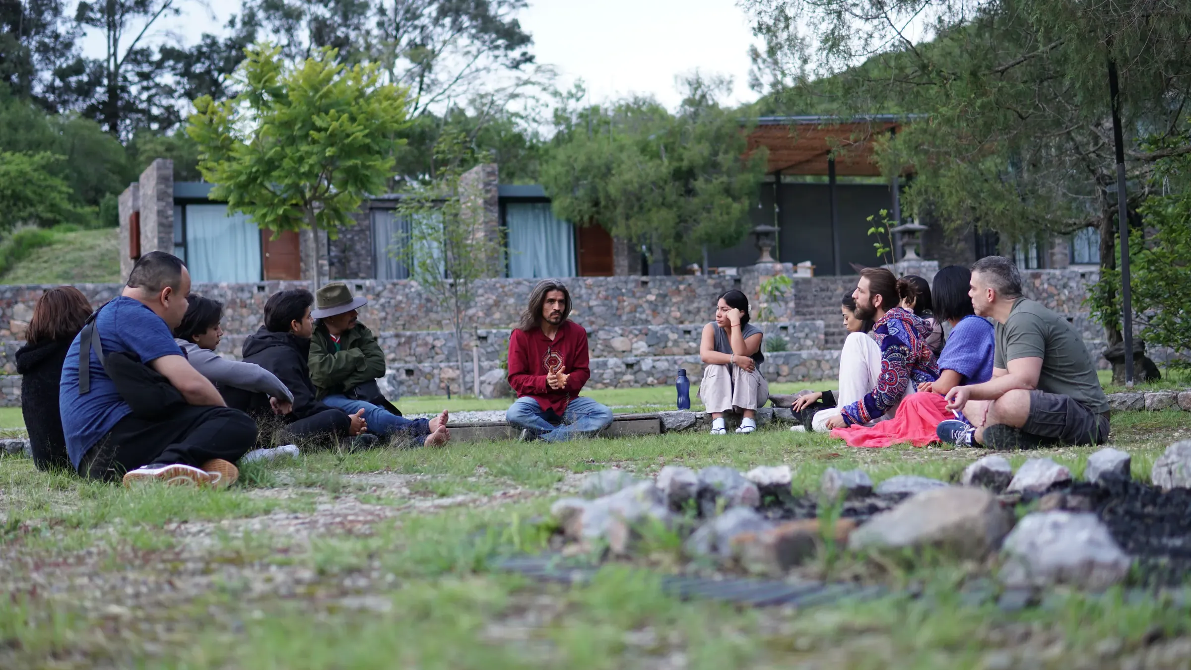Grupo sentado en círculo sobre el pasto