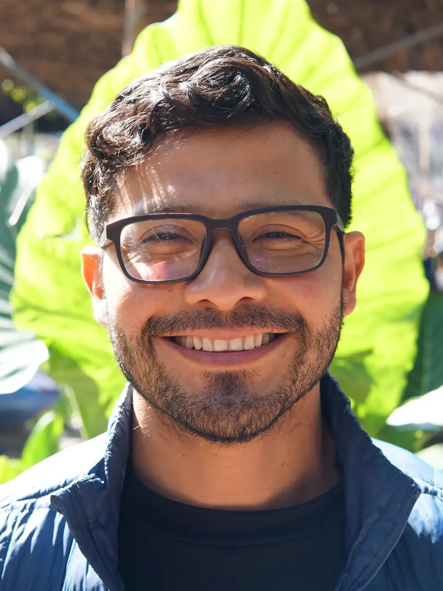Participante sonriendo entre plantas, a la mañana siguiente